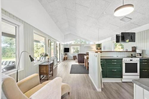 a kitchen with green cabinets and a living room at S742-Stroby-Garderhojen-32 in Strøby