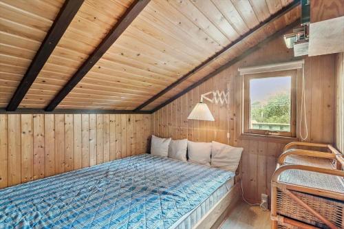 a bedroom with a bed in a wooden room at R971-Rodvig-Stuven-65 in Rødvig