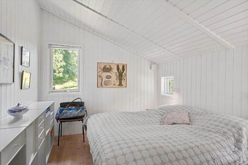 a bedroom with a bed in a white room at 3077-Stege-Bundgarnet-137-B in Stege