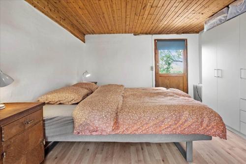 a bedroom with a bed and a wooden ceiling at 4320-Stege-Oddermose-Strandvej-5-B in Stege