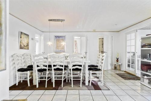 a white dining room with a table and chairs at 1305-Stege-Kaerhogevej-29 in Stege