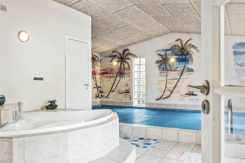 a bathroom with a tub and a swimming pool at 1305-Stege-Kaerhogevej-29 in Stege