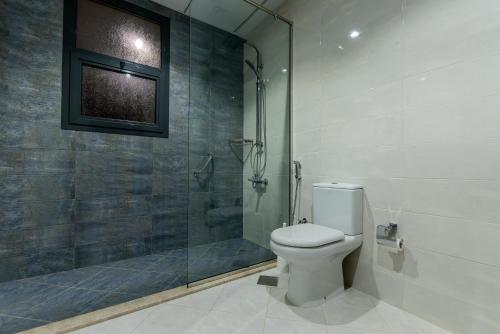 a bathroom with a toilet and a glass shower at Al Dana Marmaris Villa Fujairah in Sharm