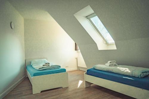a small room with two beds and a window at Appartementhaus Brunsholm in Esgrus