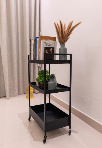 a black book shelf with books and plants at Al Dana Sea Luxury Villa Fujairah in Sharm