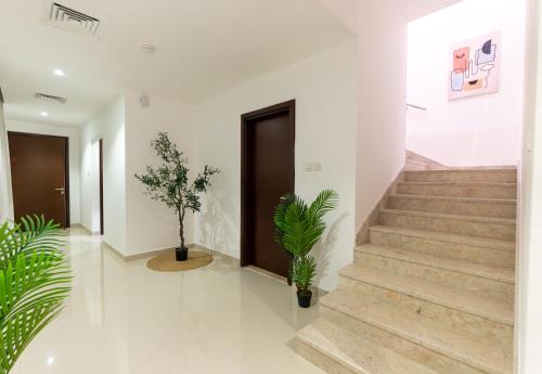 a hallway with stairs and a door and potted plants at Al Dana Sea Luxury Villa Fujairah in Sharm