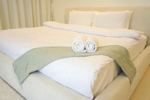 two rolled towels sitting on top of two beds at Al Dana Sea Luxury Villa Fujairah in Sharm