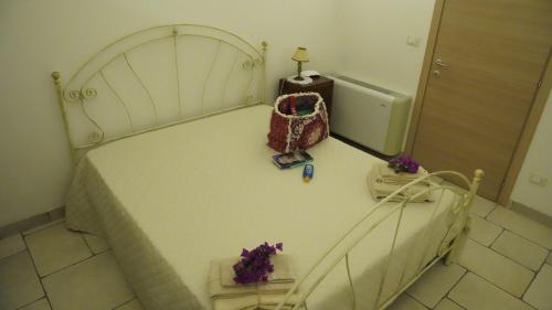 a bedroom with a white bed with a bag on it at Sottacastieddu in Avetrana