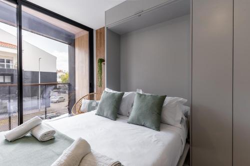 Un dormitorio con una cama blanca con una ventana grande. en Water Lily, en Aveiro