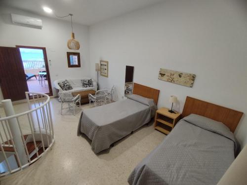 ポルト・サプラヤにあるValenciaBeachHomeのベッド2台とリビングルームのある寝室