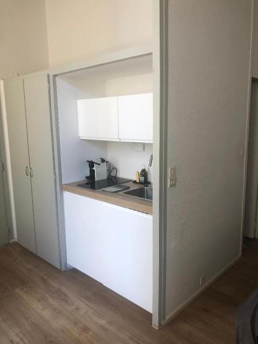 une cuisine avec des armoires blanches et un comptoir dans l'établissement Studio Anna centre historique Bordeaux St Pierre, à Bordeaux
