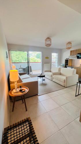 un salon avec des canapés et une table dans l'établissement Happy Hossegor, plein centre avec vue sur lac et parc Rosny, à Soorts-Hossegor