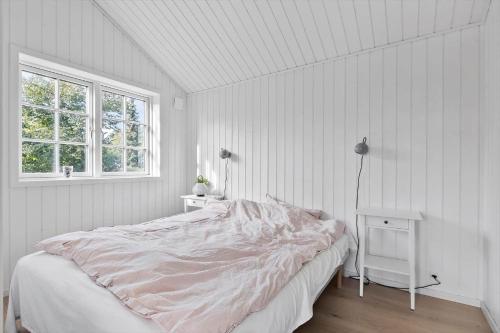 Un dormitorio blanco con una cama y una ventana. en 3011-Stege-Straektovet-18, en Stege
