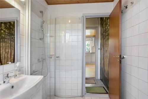 a white bathroom with a shower and a sink at 4259-Stege-Fabriksgade-14 in Stege