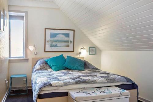 a bedroom with a bed with blue pillows at 4259-Stege-Fabriksgade-14 in Stege