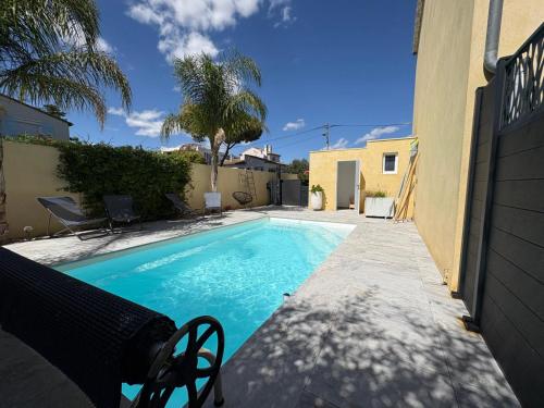 une piscine devant une maison dans l'établissement COSYFAMILY RDC 6pers-PISCINE-Jacuzzi-Jardin- Barbecue- TopPros Conciergerie Pérols, à Pérols
