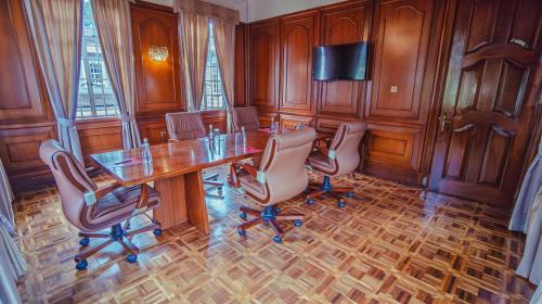 a conference room with a wooden table and chairs at Muthu Sovereign Suites & Spa, Limuru Road, Nairobi in Limuru