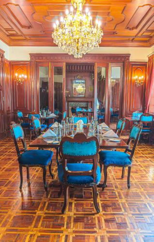 a dining room with a table and chairs and a chandelier at Muthu Sovereign Suites & Spa, Limuru Road, Nairobi in Limuru