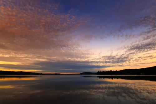 a sunset over a large body of water at Lakeside Calm at Dimensions - Cabin One in Algonquin Highlands