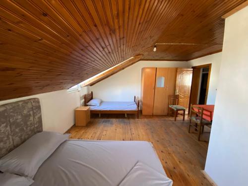 a bedroom with a bed and a wooden ceiling at Uncle house in Shkodër