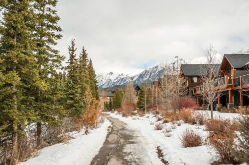 a snow covered road in front of a lodge at Spring Creek Penthouse by Canadian Rockies Vacation Rentals in Canmore