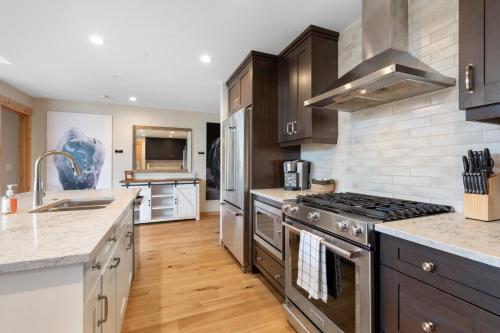 a kitchen with stainless steel appliances and wooden floors at Spring Creek Penthouse by Canadian Rockies Vacation Rentals in Canmore