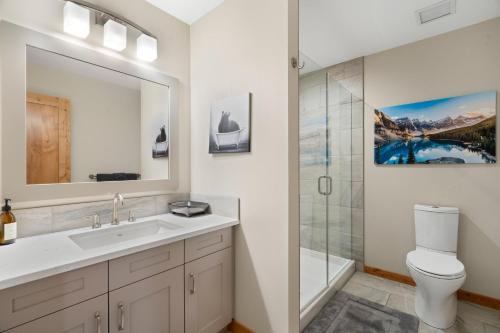 a bathroom with a sink and a toilet and a shower at Spring Creek Penthouse by Canadian Rockies Vacation Rentals in Canmore