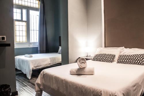 a hotel room with two beds and a window at Hostal Boutique Khronos in Barcelona