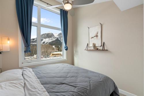 a bedroom with a bed and a large window at Casa de Luna by Canadian Rockies Vacation Rentals in Canmore