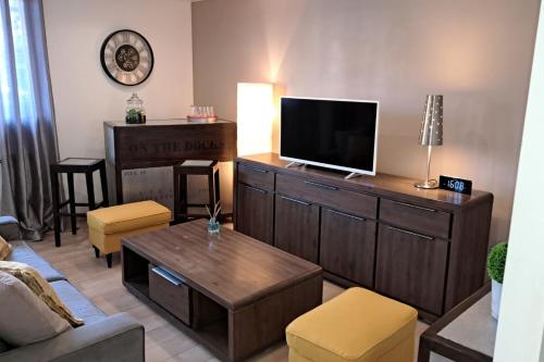 - un salon avec une télévision à écran plat sur une armoire en bois dans l'établissement A cosy and comfortable nest, à Toulouse