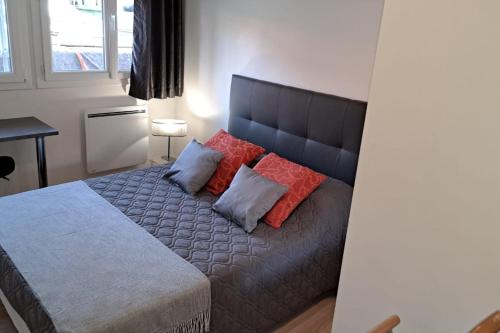 une chambre avec un grand lit avec des oreillers rouges dans l'établissement A cosy and comfortable nest, à Toulouse