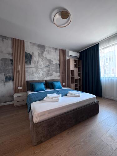 a bedroom with a large bed with blue pillows at Desire Luxury Apartment with private garage in Varna City