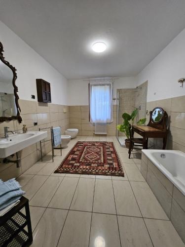 a large bathroom with a tub and a toilet and a sink at Ca' San Valentino in Pontelongo