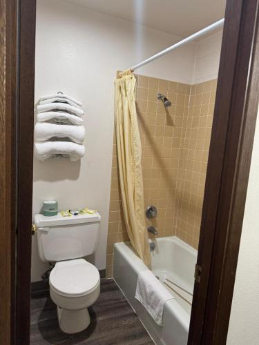 a bathroom with a toilet and a shower with towels at Capri Motel By Belvilla Walla Walla US 12 in Walla Walla
