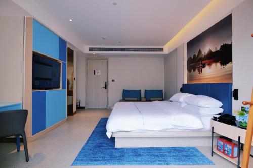 a bedroom with a large bed and a television at Magnotel Guilin Elephant Trunk Hill in Guilin
