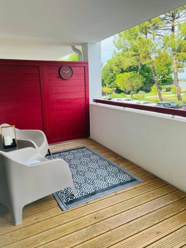 une salle de bain avec une porte rouge et un tapis noir et blanc dans l'établissement Happy Hossegor, plein centre avec vue sur lac et parc Rosny, à Soorts-Hossegor