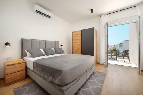 a bedroom with a large bed and a large window at Villa Ante Vodice in Vodice