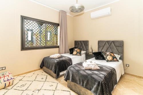 a bedroom with two beds and a window at Villa riad raffinée privée à Marrakech in Marrakech