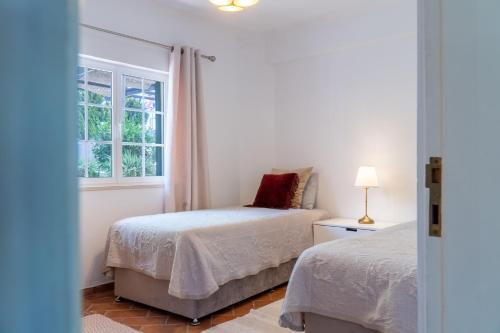 a bedroom with two beds and a window at appartement avec jardin privé dans une résidence hôtelière haut de gamme in Vilamoura