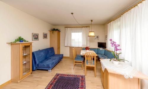 sala de estar con sofá azul y mesa en Plankensteiner Tschurtschenthaler, en Dobbiaco