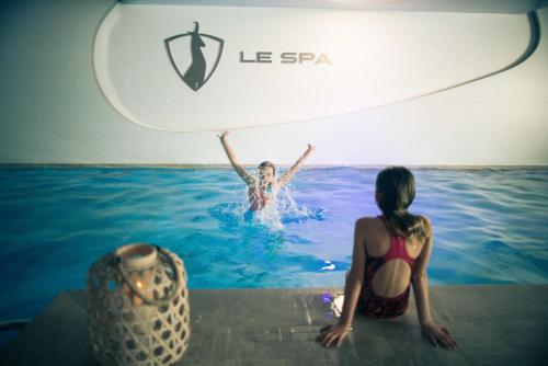 a woman in the water at a swimming pool at Hotel Pashmina Le Refuge in Val Thorens