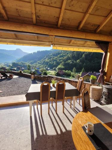 a balcony with a table and chairs and a view at RALPH Cabin- Apuseni Mountains, Transylvania in Bucium