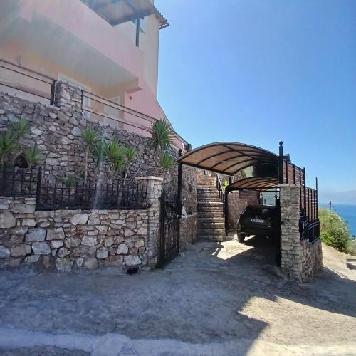 a house with a stone wall and a fence at Margherita's holidays home in Agios Spiridon Fokidas