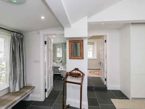 un pasillo con paredes blancas y un espejo en la pared en Pippins, en Ambleside