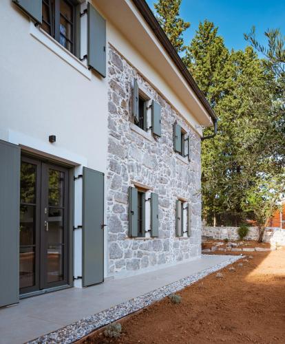 a stone house with black doors and windows at Casa Eva in Opric