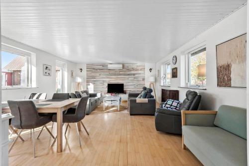 a living room with a table and chairs and a fireplace at S718-Stroby-Svalemosevej-18 in Strøby