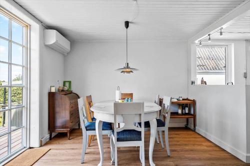 a white dining room with a white table and chairs at 4019-Stege-Udbyvej-15 in Stege