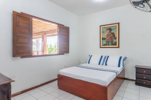 a bedroom with a bed and a window at Bela Casa com Piscina-5 Quartos-SH106D in Bezerros