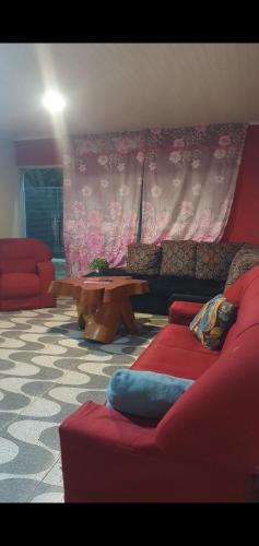 a living room with a red couch and a table at Casa con Quincho y traslado zona WRC in Cambyretá