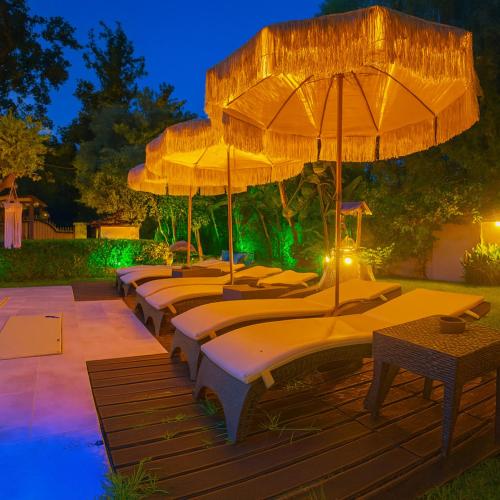 a row of beds with umbrellas on a deck at Villa Small Paradise private pool, jacuzzi, BBQ, complete privacy in Ialyssos